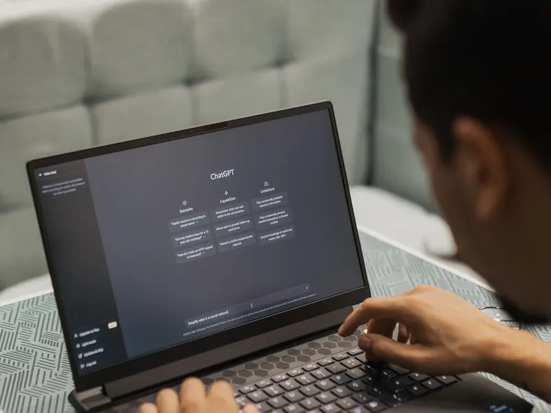Pessoa usando um assistente de IA em um notebook sobre o sofá